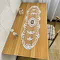 Detailed view of an elegant white lace embroidered table runner on a wooden surface - 31x100cm Table Runner / Pink