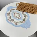 Detailed view of an oval lace placemat featuring delicate pink floral embroidery on white mesh - 36*50cm / Sky Blue