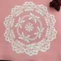 Macro detail of a white Nordic hollow embroidered circular lace placemat for table decor - 38x38cm / White