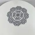 Close-up of the intricate gray embroidered lace placemat showing detailed floral patterns. - 28cm Round / Gray