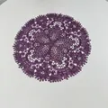 Detail view of the intricate purple embroidered lace pattern on the circular placemat - 27x27cm / Deep purple