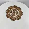 Close-up of intricate vintage style circular lace embroidered placemat on white table - 28cm Round / Brown
