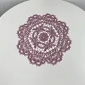 Detailed view of an intricate purple embroidered lace doily with elegant hollow-out floral patterns - 28cm Round / Mauve