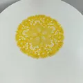 Detailed top view of a yellow embroidered lace placemat with intricate patterns. - 27x27cm / Gold