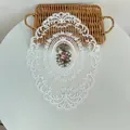Gedetailleerd overzicht van een ovale witte kanten placemat met bloemenborduurwerk - 31*42cm / Wit