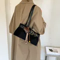 Elegante schwarze Wildleder-Baguette-Tasche mit Herzanhänger und Schnallendetail - Mit Anhänger / Schwarz