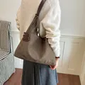 Klassische braune Tragetasche aus Wildlederimitat mit Textur und dekorativem Anhänger - Mit Anhänger / Grün