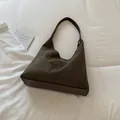 Klassische olivgrüne Hobo-Tasche aus Wildleder mit Kunstlederfuß auf weißem Bettlaken - Einzelne Tasche / Grün