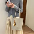 Minimalistische beige gewebte Beuteltasche im koreanischen Stil mit Perlenanhänger - Mit Anhänger / Aprikose