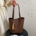 Braune gewebte Tragetasche aus weichem Leder im Retro-Stil mit Perlenanhänger-Detail. - Mit Anhänger / Braun