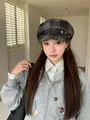 Detailed shot of a vintage grey plaid octagonal newsboy hat with buckle on a model - Black