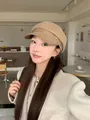 Vintage wool baker boy newsboy hat in tan with leather brim worn by a model in a cafe - Mocha