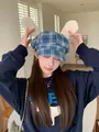 Detail of blue plaid baker boy hat with plush rabbit ears and bows for winter fashion. - Blue