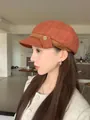 Perfil de mujer con elegante gorra de repartidor en tweed naranja quemado en interiores - Rojo Anaranjado