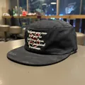 Close-up of black military cap with embroidered inspirational quote and red S logo - Classic Black