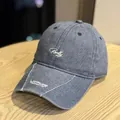 Primer plano de una gorra de béisbol vintage gris lavado con bordados de letras - Azul Denim Lavado