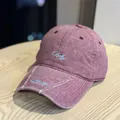 Detalle de una gorra de béisbol vintage malva con bordado de letras en la visera - Rojo Rosa Envejecido
