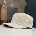Close-up detail of a beige cotton cadet military cap featuring metallic eyelet vents - Off White