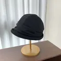 Elegant black pleated bucket hat for women shown on a premium gold stand display - Black
