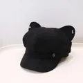 Close-up of a black newsboy hat with cute cat ears and a silver metal G logo detail. - Black