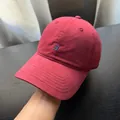 Nahaufnahme des blau gestickten Logos auf einer hochwertigen burgunderroten Baseballkappe - Softtop Gstickter Buchstabenstil / Burgunderrot