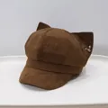 Macro view of brown suede newsboy cap featuring fox ears and metallic key charm detail - Adult 55-58cm / Small Key - Brown