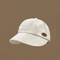 Casquette de baseball beige texturée minimaliste avec détail d'écusson en cuir mode - Blanc