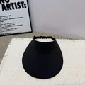 Detailansicht eines minimalistischen schwarzen Sonnenvisiers mit breiter Krempe auf Matte. - Schwarz