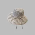 Stylish plaid pattern bucket hat with adjustable straps shown in a neutral grey studio setting - Off White
