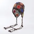 Detailed macro shot of bohemian crochet flower hat featuring handmade knit and tassels - Coffee