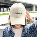 Detail of a beige baseball cap featuring Attitude embroidery and a wide brim for women. - Off White