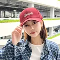 Close-up of burgundy baseball cap with Attitude embroidery worn by a stylish model - 60-65 / Burgundy