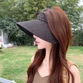 Elegante visera parasol marrón para mujer con detalles de diamantes en un entorno de jardín - Negro