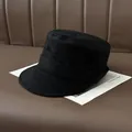 Detailed view of black pleated suede newsboy cap featuring a classic flat top design - Black