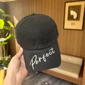 Detailed view of white Perfect cursive embroidery on a black curved brim baseball cap. - Regular (55-59cm) / Black