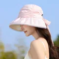 Detailed side view of a stylish pink pleated sun hat with a large bow detail. - Pink