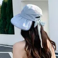Detailed back view of a pleated light blue sun hat featuring a stylish bow-tie ribbon. - Blue