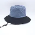Detail view of stylish two-tone blue and black bucket hat with adjustable chin strap - Black