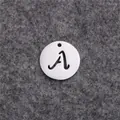 Gros plan d'un pendentif rond en acier inoxydable avec la lettre A calligraphiée évidée - Lettre A