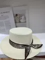 Vue détaillée d'un chapeau de paille évidé avec un ruban à motif paisley élégant - M (56-58cm) / Beige