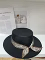 Gros plan d'un chapeau de paille noir ajouré orné d'un ruban à motif cachemire. - M (56-58cm) / Noir