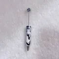 Detailed view of handmade ballpoint pen with black and white rhinestone cow print pattern - White