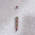 Close-up of candy-colored rhinestone ballpoint pen with pink and green crystals - Pink