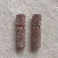 Primo piano di bottiglie spray per profumo vuote da 10ml portatili con strass brillanti - Bordo dorato / Rosa