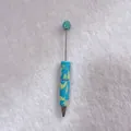 Close-up detail of candy-colored rhinestone ballpoint pen with blue and yellow patterns - Lake Blue