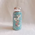 Detailansicht der blauen diamantbesetzten Thermoskanne mit elegantem Blumenmotiv - 260ml / Blau