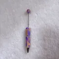 Detailed view of handmade rhinestone ballpoint pen with vibrant candy-colored beads - Purple