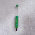 Close-up of candy-colored rhinestone ballpoint pen with handcrafted crystal detail - Green