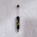 Detailed view of a handmade rhinestone ballpoint pen with black and yellow crystal pattern - Black