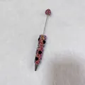 Macro detail of handmade colorful rhinestone beadable pen with black heart-shaped jewels. - Large Red with AB Rhinestone Heart
